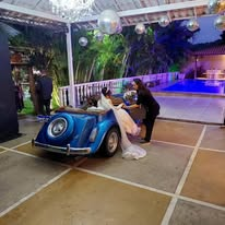 Carro clássico decorado na área da piscina durante festa noturna